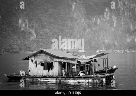 Immagine in bianco e nero di una casa galleggiante sulla baia di Halong vicino a Cat Ba Island in Vietnam Foto Stock