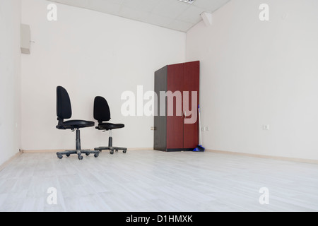 Due sedie e un armadio in un ufficio vuoto camera Foto Stock