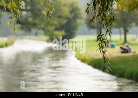 Persone rilassante accanto Eisbach in Englischer Garten Monaco di Baviera, Bavarie, Germania Foto Stock