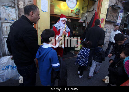 Dic. 23, 2012 - Ramallah, West Bank, Territorio palestinese - palestinesi uomo vestito da Santa Claus passeggiate in riva a ovest della città di Ramallah il 23 dicembre 2012 .Il Natale è celebrato i cristiani di tutto il mondo il 25 dicembre di ogni anno (immagine di credito: © Issam Rimawi APA/images/ZUMAPRESS.com) Foto Stock