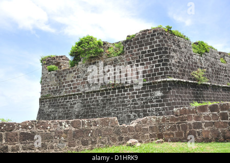 Blue sky view massicci bastioni di pietra verde con alberi, nell'estremità sud-est Fort Frederick, St George's, Grenada, West Indies Foto Stock