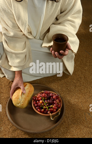 Gesù mani tenendo la comunione simboli: il pane e il vino Foto Stock