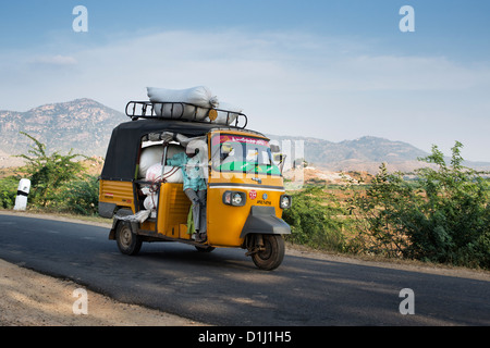 Indian auto rickshaw sovraccaricato con sacchi di riso su una strada di campagna. Andhra Pradesh, India Foto Stock