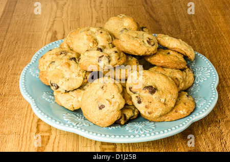 Piastra di colore blu con i biscotti al cioccolato su un tavolo di legno Foto Stock