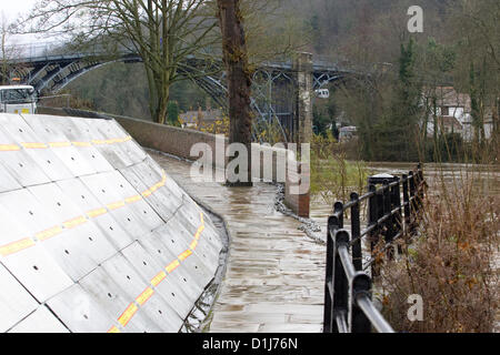 Ironbridge, UK. 24 dic 2012. Barriere antiesondazione sono state erette nella città di Ironbridge in Shrophire per proteggere il locale di edifici da inondazioni come il fiume Severn continua a salire. L'Ironbridge, il primo ponte di ferro in tutto il mondo, è stato costruito nel 1779. Foto Stock