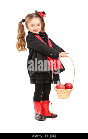 A piena lunghezza Ritratto di una bambina tenendo un cestello con le mele rosse isolato su sfondo bianco Foto Stock