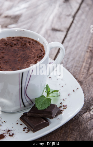 La tazza con il cioccolato caldo, pezzi di cioccolato e menta Foto Stock