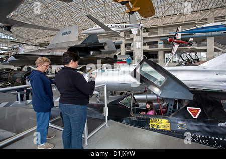 Ragazza che gioca all'interno di un aereo di combattimento cockpit. Il museo del volo. Seattle. Stati Uniti d'America Foto Stock