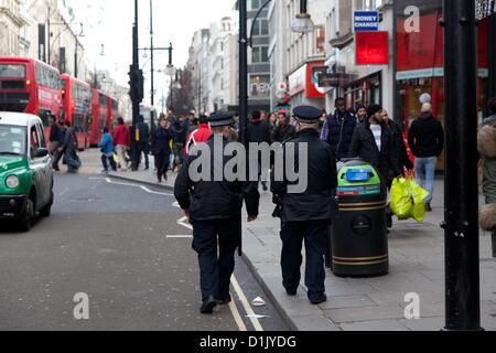 Londra, Regno Unito. 26 dicembre 2012 poliziotti passano un il negozio per Foot Locker su Oxford Street che è stato il sito di un accoltellato sul Boxing Day lo scorso anno. A causa della gli assalti violenti lo scorso anno su Oxford Street ci sono più agenti di polizia in servizio di pattugliamento a Londra il più trafficate aree dello shopping. Foto Stock