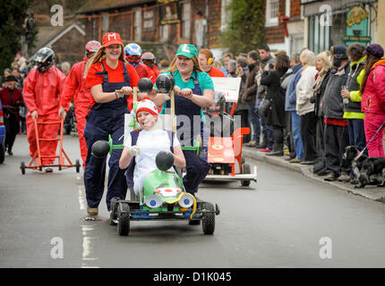 East Hoathly, UK. Il 26 dicembre 2012. East Hoathly Boxing Day pram - GARA - folla rivestita la East Sussex village High Street come team raccolti e fatti correre loro wacky macchine tra i due pub per la carità. Donna Cottingham (sinistra), Becca Frizzell (destra) e Robyn Frizzell presso i comandi come essi impostato su off all'inizio della gara. Credito: Jim Holden / Alamy Live News Foto Stock