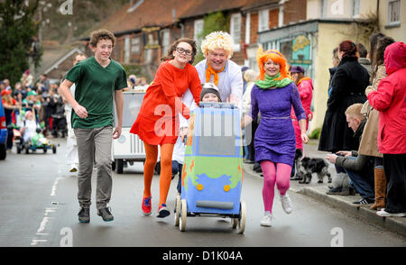 East Hoathly, UK. Il 26 dicembre 2012. East Hoathly Boxing Day pram - GARA - folla rivestita la East Sussex village High Street come team raccolti e fatti correre loro wacky macchine tra i due pub per la carità. Un team vestito di Scooby Doo fancy dress eseguire attraverso il villaggio. Credito: Jim Holden / Alamy Live News Foto Stock