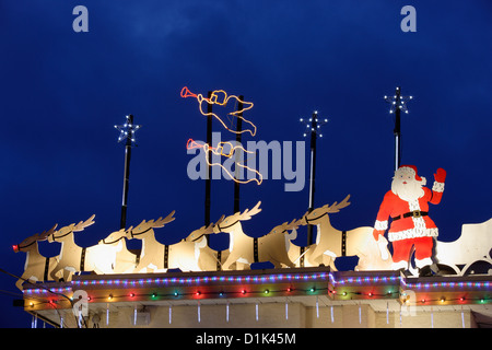 Babbo Natale e la sua renna sulla parte superiore della casa illuminata a Natale annuale stagione.-Victoria, British Columbia, Canada. Foto Stock