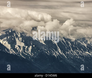 Giugno 30, 2012 - Girdwood, Alaska, USA - incorniciata e parzialmente oscurata, dai drammatici ondeggianti formazioni di nubi, le imponenti cime innevate dell'imponente Kenai Mountain Range salire al di sopra del braccio Turnagain, 50 mi [80 km] fjord alimentato da Cook Inlet. Fotografato da Mt Alyeska in Girdwood, Alaska, 27 miglia (44 km) da Anchorage. (Credito Immagine: © Arnold Drapkin/ZUMAPRESS.com) Foto Stock