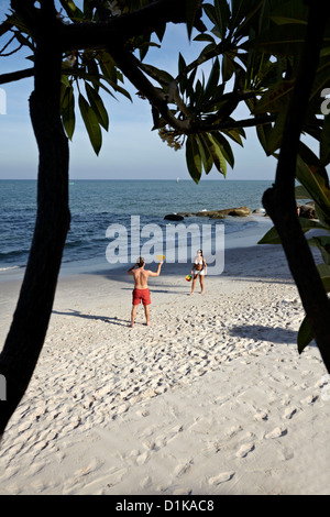 Giovane coppia che gioca a bat e palla a Hua Hin spiaggia tropicale Hua Hin Thailandia S. E. Asia Foto Stock