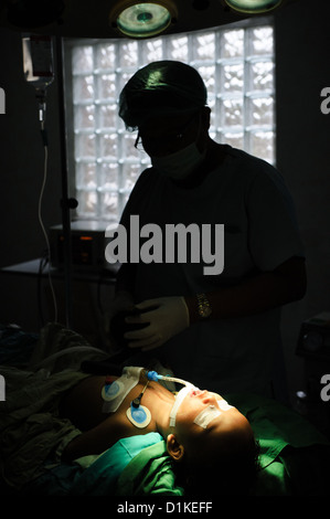 Un giovane bambino giacente in un teatro operativo dopo la chirurgia per riparare una spaccatura nel suo palato molle, Bali, Indonesia. Foto Stock