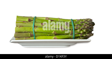 Gli asparagi verdi su una piastra con tipici nastri di gomma Foto Stock