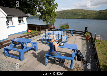 Giovani donne in seduta Old Inn Beer Garden, Carbost, Isola di Skye; Scozia Foto Stock