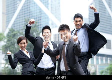 Eccitati per persone d' affari fustellatura dell'aria e celebrando, Hong Kong Foto Stock