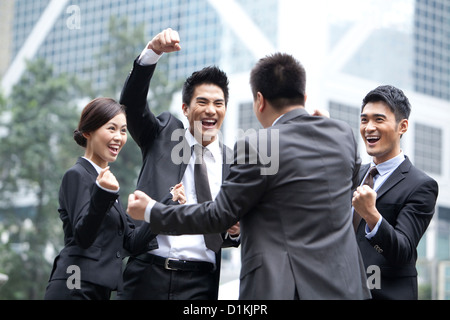 Eccitati per persone d' affari fustellatura dell'aria e celebrando, Hong Kong Foto Stock