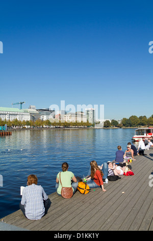 Le persone che si godono il sole su un molo al Jungfernstieg in Amburgo, Germania Foto Stock