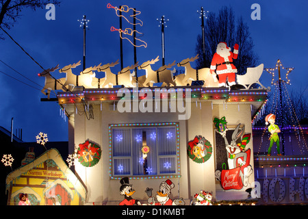 Babbo Natale e la sua renna sulla parte superiore della casa illuminata a Natale annuale stagione.-Victoria, British Columbia, Canada. Foto Stock