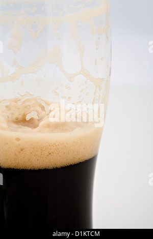 Un drenato mezza pinta di birra Stout Foto Stock