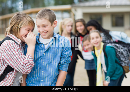 Scuola caucasica boys whispering insieme Foto Stock