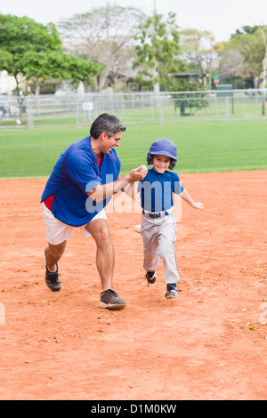 Pullman ispanica e giovane giocatore di baseball Foto Stock