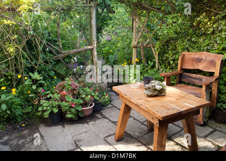 Area relax su un patio in stile rustico con mobili da giardino,. Foto Stock