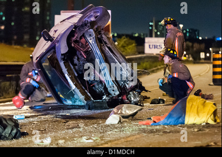 Paramedici e scontri a fuoco il lavoro di stabilizzare un uomo che è stato gettato dal suo minivan quando è arrotolato su 401 in direzione ovest ovest Foto Stock