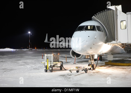 Air Canada embraer e-jet su supporto a congelato coperto di neve aeroporto di Saskatoon Saskatchewan Canada Foto Stock