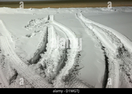 Auto parcheggiata tracce di pneumatici nella neve in un parcheggio Saskatoon Saskatchewan Canada Foto Stock