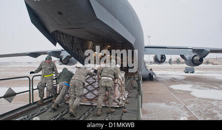 La ALTUS AIR FORCE BASE, Okla. - 97Th disponibilità logistica squadrone operazioni aeree membri di volo spingere un pallet caricato con il cibo nel retro di un C-17 Globemaster III, Dic 28, 2012. Dopo il caricamento di 137.000 libbre di fagioli e riso, membri della cinquantottesima Airlift Squadron trasportato il cibo a Port-au-Prince, Haiti a sostegno dell'emendamento Denton, un programma che offre sollievo ai cittadini haitiani rendendo il trasporto di aiuti umanitari possibili. Le merci trasportate ad Haiti sono stati donati dal funzionamento dell'Ucraina, US Air Force foto Foto Stock