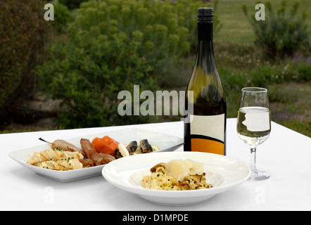 Un antipasto per la piastra di degustazione e una ciotola di Risotto ai funghi, accompagnato da un bicchiere di Chardonnay Foto Stock