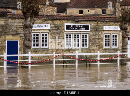 Gonfiore al fiume Avon che provocano inondazioni nel centro della città a Bradford-on-Avon, con acqua proveniente per la porta di un locale commerciale Foto Stock