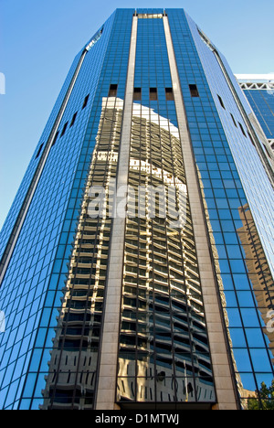 Le riflessioni nella facciata di vetro di un grattacielo adiacenti di una vicina torre di uffici Foto Stock