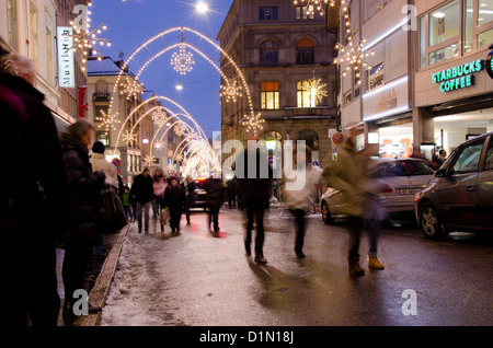La Svizzera, Basilea. Holiday Lights su Freie Strasse, vicino Munsterplatz, Su occupato notte d'inverno. Foto Stock