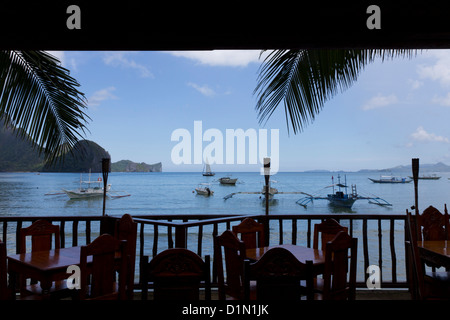 Bancas (catamarani) siede serenamente, El Nido Bay, Palawan Foto Stock