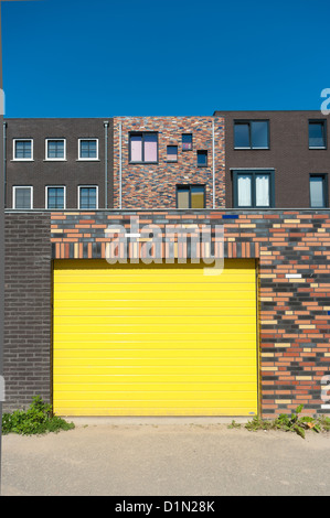 Vista posteriore di nuova costruzione di nuove e moderne case nei Paesi Bassi con un giallo porta di garage Foto Stock