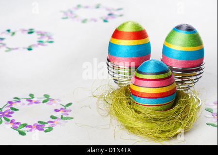 Fatte a mano uovo di Pasqua su una tovaglia ricamata Foto Stock