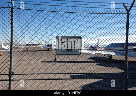 Catena di sicurezza link scherma con attenzione area riservata segno sul perimetro dell'aeroporto mccarran Las Vegas Nevada USA Foto Stock