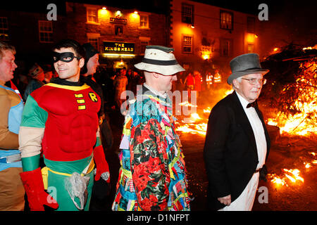 Allendale, Northumberland, Regno Unito. Il 1 gennaio 2013. Gli uomini in abiti fantasiosi partecipare al Capodanno Tar Bar'l (Tar Barrel) Celebrazioni in Allendale, Northumberland. I tradizionali festeggiamenti che coinvolgono il villaggio gli uomini che trasportano la masterizzazione di barili Foto Stock