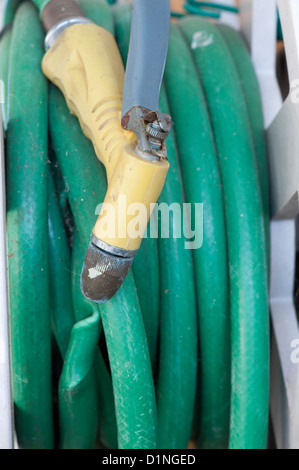 Primo piano di un vecchio giardino verde casa con una materia plastica e metallo attaccato di ugello Foto Stock