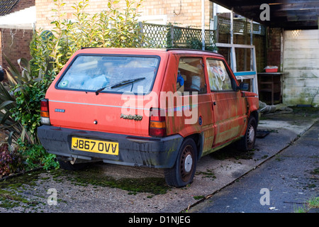 Fatiscenti autovetture utilizzate per la memorizzazione di spazzatura nel fronte di eseguire down house Foto Stock