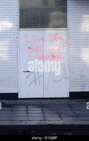 Graffiti su porte dicendo 'vivere la vita, questo non è un rehersal #YOLO' (si vive una volta sola) Foto Stock