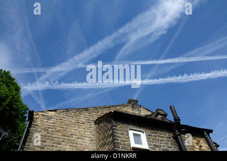 Correnti a getto, contrails nel cielo blu al di sopra di una casa di Londra Foto Stock