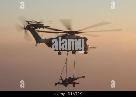 Due Stati Uniti Marine Corps CH-53E Super stalloni con Marine elicottero pesante Squadron (HMH) 361, Marine Aircraft Group 16, terzo aeromobile Marina Wing (avanti), sollevamento esterno M777 obici sulla provincia di Helmand, Afghanistan, Dic 29, 2012. HMH-361 fornito Foto Stock