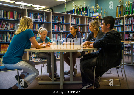 Un junior high school consigliere risponde con un gruppo multietnico di studenti in una San Clemente, CA, biblioteca scolastica. Foto Stock