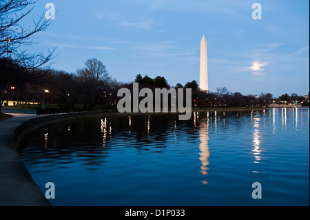 Il Monumento a Washington e la luna al tramonto con la riflessione nel bacino di marea Foto Stock