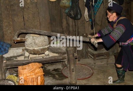 Nero donna Dao macina grano nella sua casa in un villaggio di montagna vicino a SAPA, Vietnam. Foto Stock